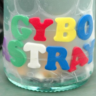 Radio Clash 128: GYBOAT Down T’Mills GYBO ASTRAY cover shows ashtray with multi coloured letters attached eclectic mashup music podcast  